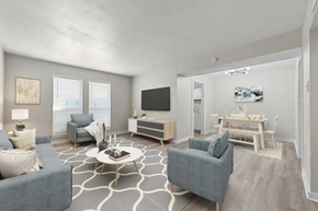 Dallas apartment for rent - A living room with a grey couch, a white coffee table, and a television.