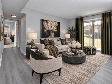 Fayetteville apartment for rent - A living room with a grey sofa, a round coffee table, and a painting of a woman.