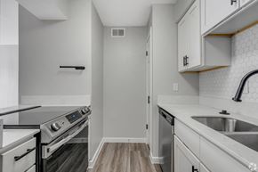 Dallas apartment for rent - A kitchen with a stove top oven and a dishwasher. at Cottonwood, Dallas