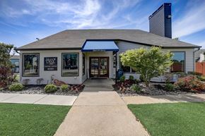 Arlington apartment for rent - the front of a white building with a sidewalk and lawn