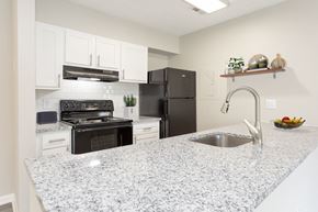 Fayetteville apartment for rent - a kitchen with granite counter tops and black appliances at The Hampton, Fayetteville, NC