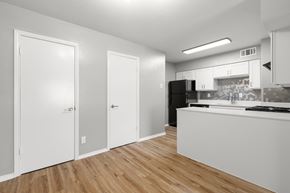 Sherman apartment for rent - A kitchen with white cabinets and a black fridge.at The Sidney, Sherman Texas