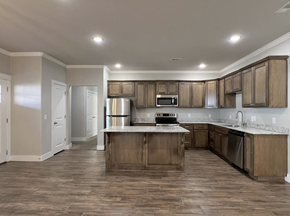 Farmington triplex for rent - A kitchen with wooden cabinets and a central island at Cedar Crest Apartments, Arkansas