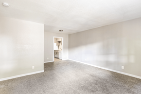 Richardson apartment for rent - A spacious room with a carpeted floor and a doorway leading to another room. at Oaks at Spring Valley, Texas