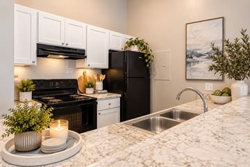 Fayetteville apartment for rent - A modern kitchen with a black refrigerator and white cabinets.