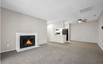 A living room with a fireplace and a ceiling fan