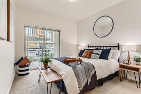 Fairview apartment for rent - Fairview Apartments for Rent - Lodges at Lake Salish - Bedroom with Bed, Nightstands, Lamps, and Sliding Glass Door