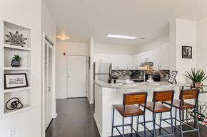 Portland apartment for rent - a kitchen with a bar and stools and a refrigerator