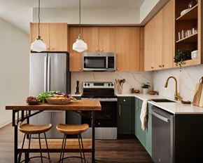 Portland apartment for rent - a kitchen with wooden cabinets and a table with three stools