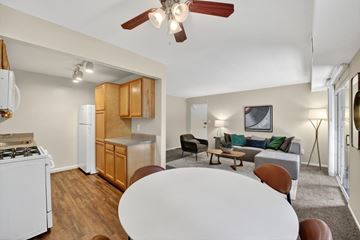 Washington apartment for rent - A living room with a white table and brown chairs.