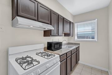 Hyattsville apartment for rent - A kitchen with a white stove and brown cabinets.
