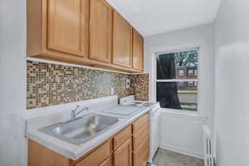 Essex apartment for rent - A kitchen with wooden cabinets and a tiled backsplash.