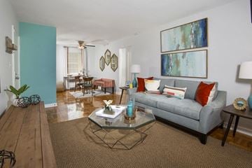 Mt Rainier apartment for rent - A living room with a grey couch and a glass coffee table.