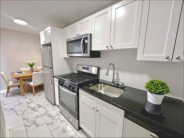 Bethesda apartment for rent - A kitchen with a black counter top and white cabinets.
