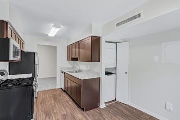 Silver Spring apartment for rent - A kitchen with brown cabinets and a black stove top oven.