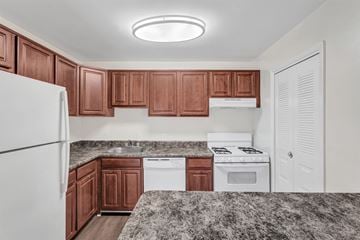 Silver Spring apartment for rent - A kitchen with brown cabinets and white appliances.