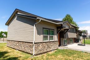 Walla Walla triplex for rent - a house with a stone wall on the side of it