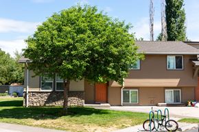 Walla Walla triplex for rent - a house with a tree and two bikes parked in front of it