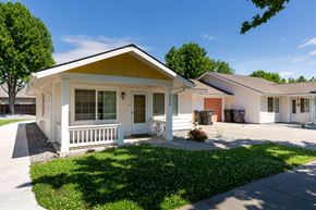 Walla Walla triplex for rent - a white bungalow with a porch and a sidewalk in front of a house