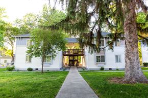 Walla Walla apartment for rent - the front of a white house with trees and a sidewalk