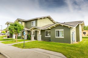 Walla Walla triplex for rent - a green house with a lawn and a sidewalk
