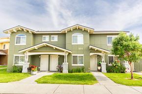 Walla Walla triplex for rent - a green house with a lawn and a tree in front of it