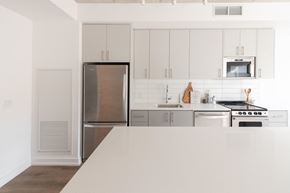 Toronto apartment for rent - a white kitchen with stainless steel appliances and white cabinets