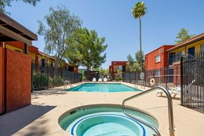 Tucson apartment for rent - A pool surrounded by red buildings and trees.