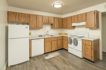 Tucson apartment for rent - A kitchen with wooden cabinets and white appliances.