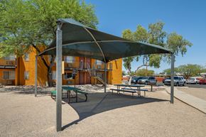 Tucson apartment for rent - A playground with a green canopy and a picnic table.