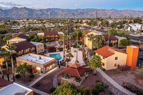 Tucson apartment for rent - A sunset view of a neighborhood with a pool and a mountain in the background.