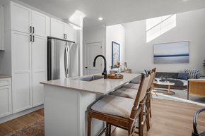 Highland townhouse for rent - A kitchen with a refrigerator, sink, and a dining table with chairs.