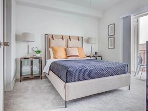 Salt Lake City apartment for rent - A bedroom with a large bed and a small table with a lamp.
