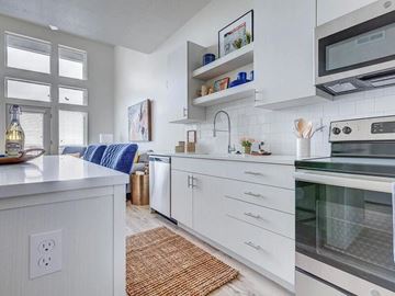 Salt Lake City apartment for rent - A modern kitchen with white cabinets and a blue cushion on the counter.