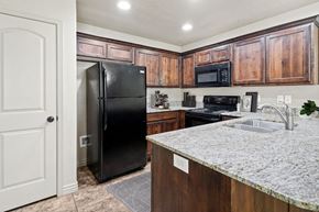 Layton townhouse for rent - a kitchen with a granite counter top and a black refrigerator