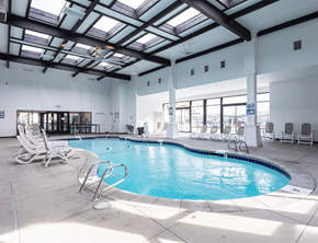 Orem apartment for rent - A large indoor swimming pool with sun loungers.