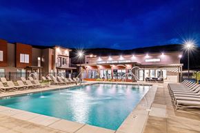 St. George townhouse for rent - A swimming pool area with lounge chairs and a building in the background.