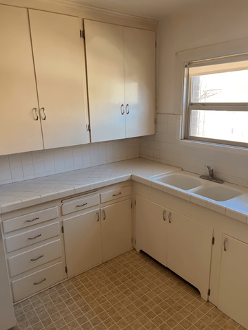 Salt Lake City apartment for rent - A kitchen with white cabinets and a tiled floor.