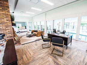 Orem apartment for rent - A modern office space with a brick wall and wooden flooring.