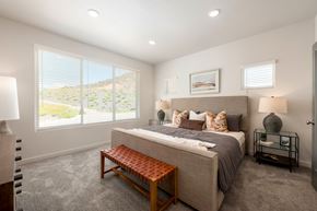 St. George townhouse for rent - A bedroom with a large bed and a bench in front of it.