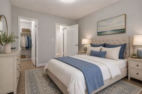 Roy apartment for rent - A bedroom with a large bed and a painting of a beach scene on the wall.