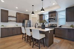 Riverdale townhouse for rent - A modern kitchen with a center island and white chairs.