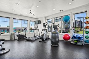 Roy apartment for rent - A gym with a variety of equipment including a treadmill, exercise bike, and weights.