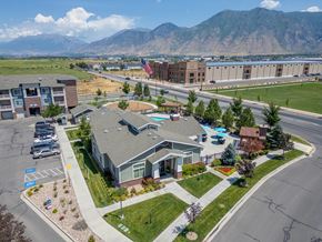 Springville apartment for rent - A large building with a flag on top is surrounded by a parking lot and other buildings.