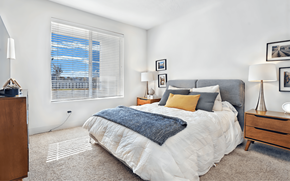 West Jordan apartment for rent - A bedroom with a large bed and a window with blinds.