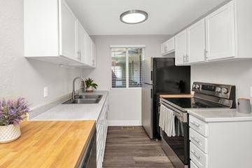 Ogden apartment for rent - A kitchen with white cabinets and a black refrigerator.