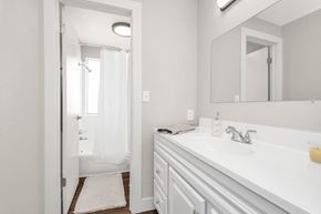 Ogden apartment for rent - A white bathroom with a sink, mirror, and shower.