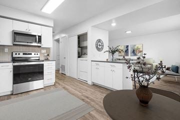 Ogden apartment for rent - A modern kitchen with white cabinets and a grey rug on the floor.