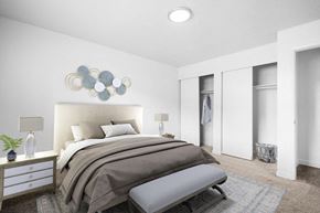 Ogden apartment for rent - A bedroom with a large bed and a bench in front of it.