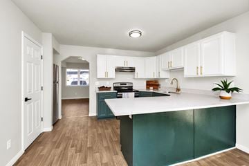 Ogden townhouse for rent - A kitchen with white cabinets and a green island.